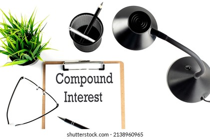 COMPOUND INTEREST text on clipboard on the white background - Powered by Shutterstock