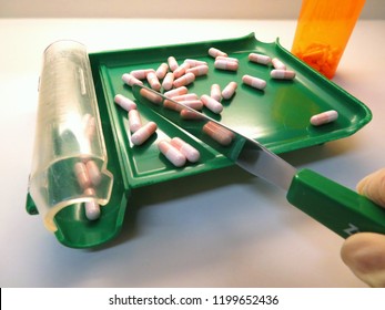 Compounded Pink And White Gelatin Capsules Being Counted By A Pharmacist (pharmacy Technician) On A Green Counting Tray.