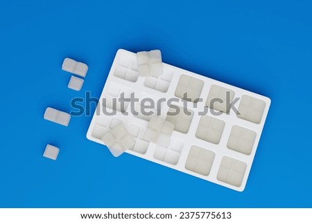 Compounded, white square flex dose troches (lozenges) in a white, plastic mold on a blue countertop in a compounding pharmacy. Easy to taper and adjust dosing.