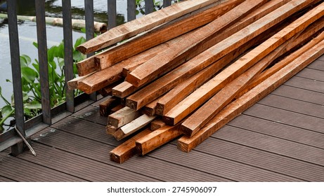 Comprehensive construction site imagery featuring bundles of timber lumber on composite decking and heavy structural support pillars against a stone wall for industrial and building projects.