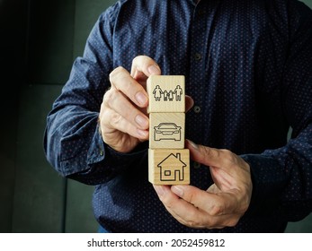 Comprehensive insurance coverage. Man holds cubes with home, car and family. - Shutterstock ID 2052459812