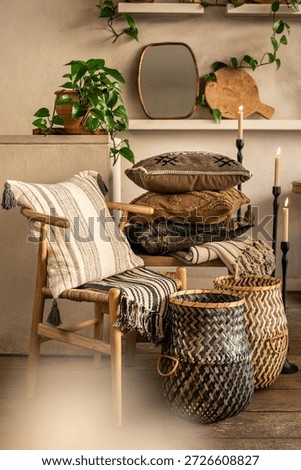 A comprehensive interior styling scene featuring a light wood Wishbone chair with a striped cushion, a stack of boho pillows on a wooden bench, and green geometric woven baskets. The warm atmosphere i