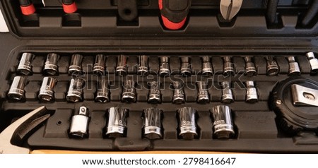 Comprehensive mechanic's tool set featuring a wide array of chrome socket wrenches, a hammer, pliers, and other hand tools, meticulously organized in a durable black plastic hard case, representing readiness for repair and DIY projects.