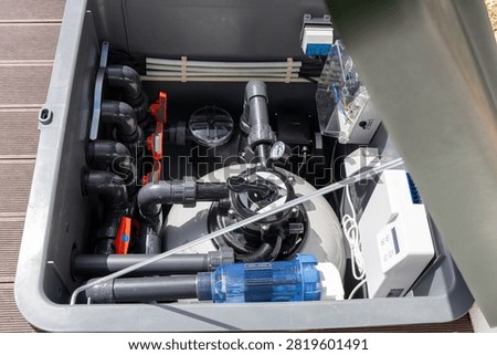 A comprehensive view inside a pool equipment box showcasing the intricate network of pipes, valves, and electronic controls for water purification