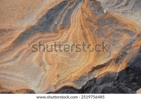 The compressed sedimentary rocks display irregular ripples, resembling a work of art in nature.

