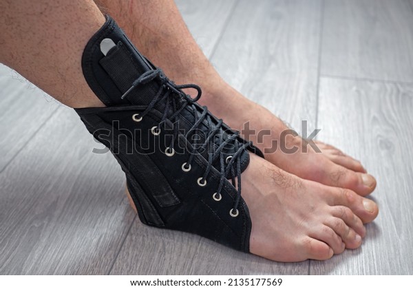 compression fixed\
in ankle stabilizer medical bandage. Fracture or Leg sprain injury\
of young sports man. Lacing and tight fit of the foot.\
Post-fracture therapy and development.\
