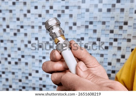 Compression ring is visible at end of composite pipe as plumber prepares to install compression fitting for joining two sections in plumbing system.