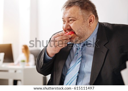 Compulsive immoderate guy engulfing junk food