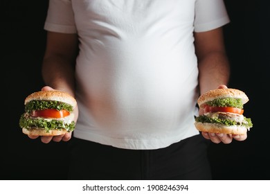 Compulsive Overeating, Obesity Prevention, Diet, Unhealthy Eating. Overweight Man With Two Tasty Hamburgers