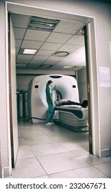 Computed Tomography Scan With Male Patient And Female Doctor. View From Outside Hospital Room.