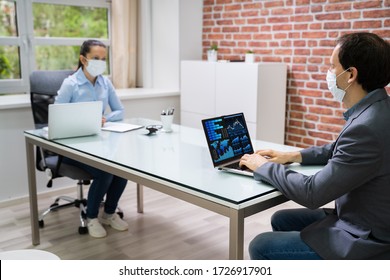 Computer Analyst Working On Laptop Wearing Face Mask - Powered by Shutterstock