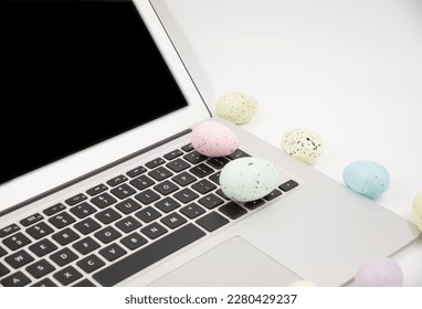 Computer with blank empty screen on white background of easter eggs. Space for text. Happy Easter! 