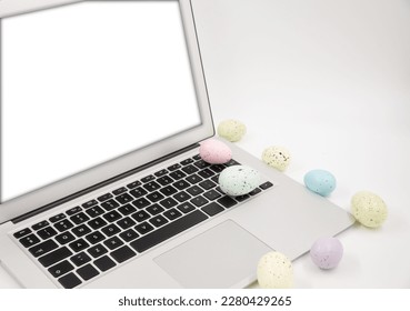 Computer with blank empty screen on white background of easter eggs. Space for text. Happy Easter! 