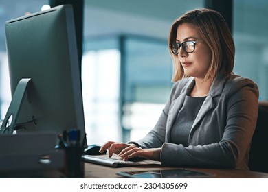 Computer, business woman and typing in office, working late on project and focus at night. Desktop, professional and female person writing email, report or planning, reading and overtime for deadline - Powered by Shutterstock