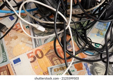 Computer Cables - Photo On Money Bank Notes. Computer Cables Is Laying On Money Bank Notes. Dollars And Euro Banknotes As Background For Electronics Chaos. Price Of Network Cords. Tangled Wires.