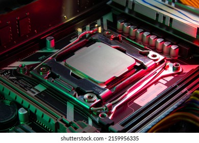 computer central processing unit on the motherboard close-up in red and green lighting
