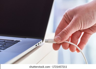 Computer Charger In Hands Close Up. Low Battery At Laptop 