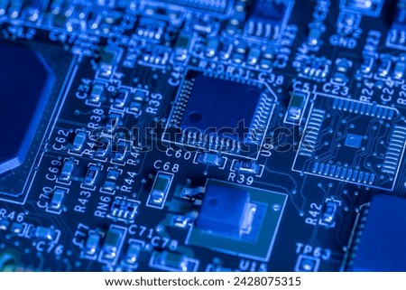 computer circuit board with chips and different electronic components. toned blue. closeup view.