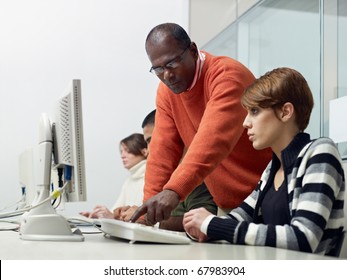 Computer Class With Indian Male Teacher Helping Female Student. Horizontal Shape, Side View, Waist Up, Copy Space