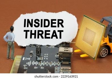 Computer concept. On the board with microcircuits lies a paper plate with the inscription - Insider Threat. Nearby is a toy loader with a processor and a human figurine.