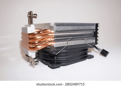 Computer CPU cooler showing copper heat pipes and aluminum fin stack. Black cooling fan with power connector visible. White background product photography for computer hardware and cooling systems.