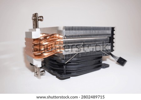 Computer CPU cooler showing copper heat pipes and aluminum fin stack. Black cooling fan with power connector visible. White background product photography for computer hardware and cooling systems.