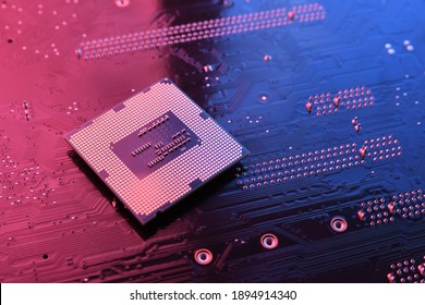 Chip de procesador de la CPU de la computadora en la placa de circuito, fondo de la motherboard. Acercamiento. Con iluminación rojo-azul.