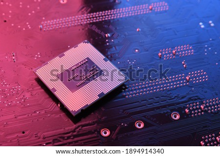 Computer cpu processor chip on circuit board ,motherboard background. Close-up. With red-blue lighting.