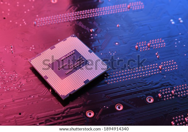 Computer cpu processor\
chip on circuit board ,motherboard background. Close-up. With\
red-blue lighting.
