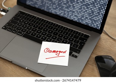 Computer damaged, note on the keyboard of a laptop. Warning, defect, malfunction, error,  interruption, binary code, failure, noise, break down, computer bug, interference, device screen.