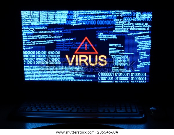 Computer in dark with word\
virus