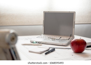 computer desk, glasses, note pad and an apple