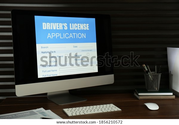Computer with driver\'s license application form on\
table in office