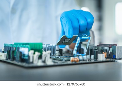 Computer Engineer Assembly Microprocessor CPU Into Electronic Motherboard., Close-up Of Technician Putting Microchip To Circuit Computer Mainboard In Manufacturing Factory., Business Technology.