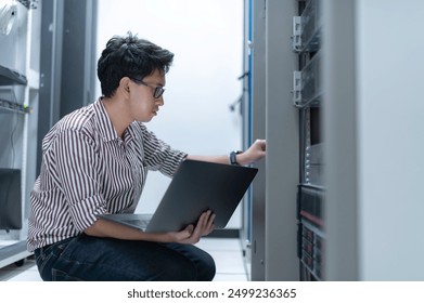Computer engineer is setting up network in server room,Systems Maintenance Technician,Male engineer working in server room at modern data center