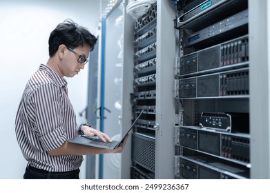 Computer engineer is setting up network in server room,Systems Maintenance Technician,Male engineer working in server room at modern data center