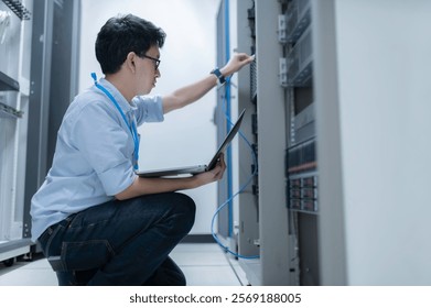 Computer engineer is setting up network in server room,Systems Maintenance Technician,Male engineer working in server room at modern data center
