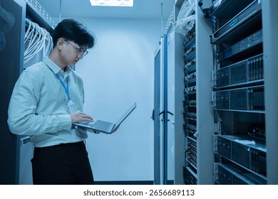 Computer engineer is setting up network in server room,Systems Maintenance Technician,Male engineer working in server room at modern data center
