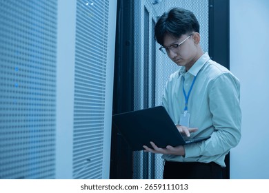 Computer engineer is setting up network in server room,Systems Maintenance Technician,Male engineer working in server room at modern data center