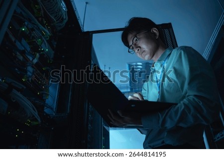 Computer engineer is setting up network in server room,Systems Maintenance Technician,Male engineer working in server room at modern data center