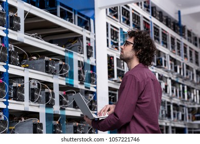 computer engineer working with laptop at cryptocurrency mining farm