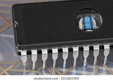 Computer erasable programmable read-only memory chip on flex PCB membrane detail. Digital EPROM integrated circuit with round window to erase data by UV light. Thin silver wires on die in DIP package.