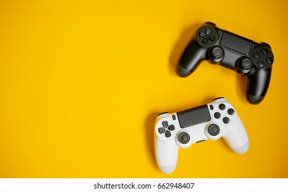Computer game competition. Gaming concept. White and black joysticks on yellow background.