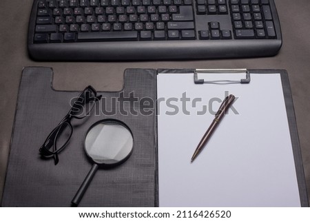  computer with glases, note, magnifier  at the office.