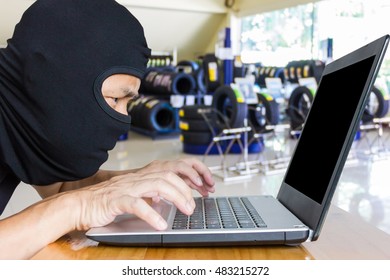 Computer Hacker, Blur Image Of Inside The Tire Shop As Background.