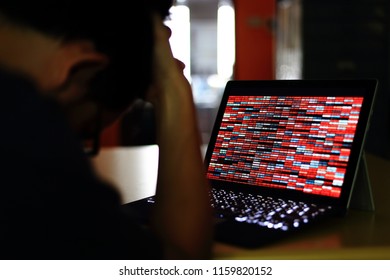 Computer Hacker silhouette typing on computer in a dark room. Working on binary code technology. binary data, computer crime and network security concepts.
