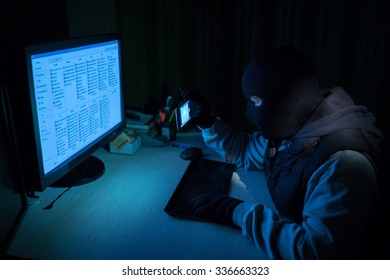 Computer hacker with smart phone make photo and data on it - Shutterstock ID 336663323