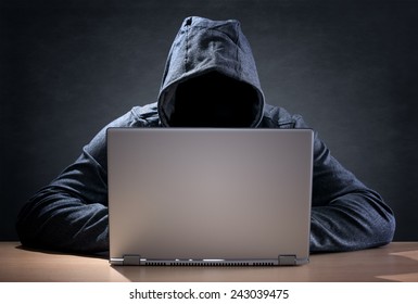 Computer hacker stealing data from a laptop concept for network security, identity theft and computer crime