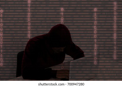 computer hacker using laptop in the dark. The man breaks access to steal information and infect computers, systems. hacking, network security, identity theft, internet crime with 01 code binary number