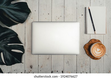 The computer and hands are working on the table with the coffee And trees at home